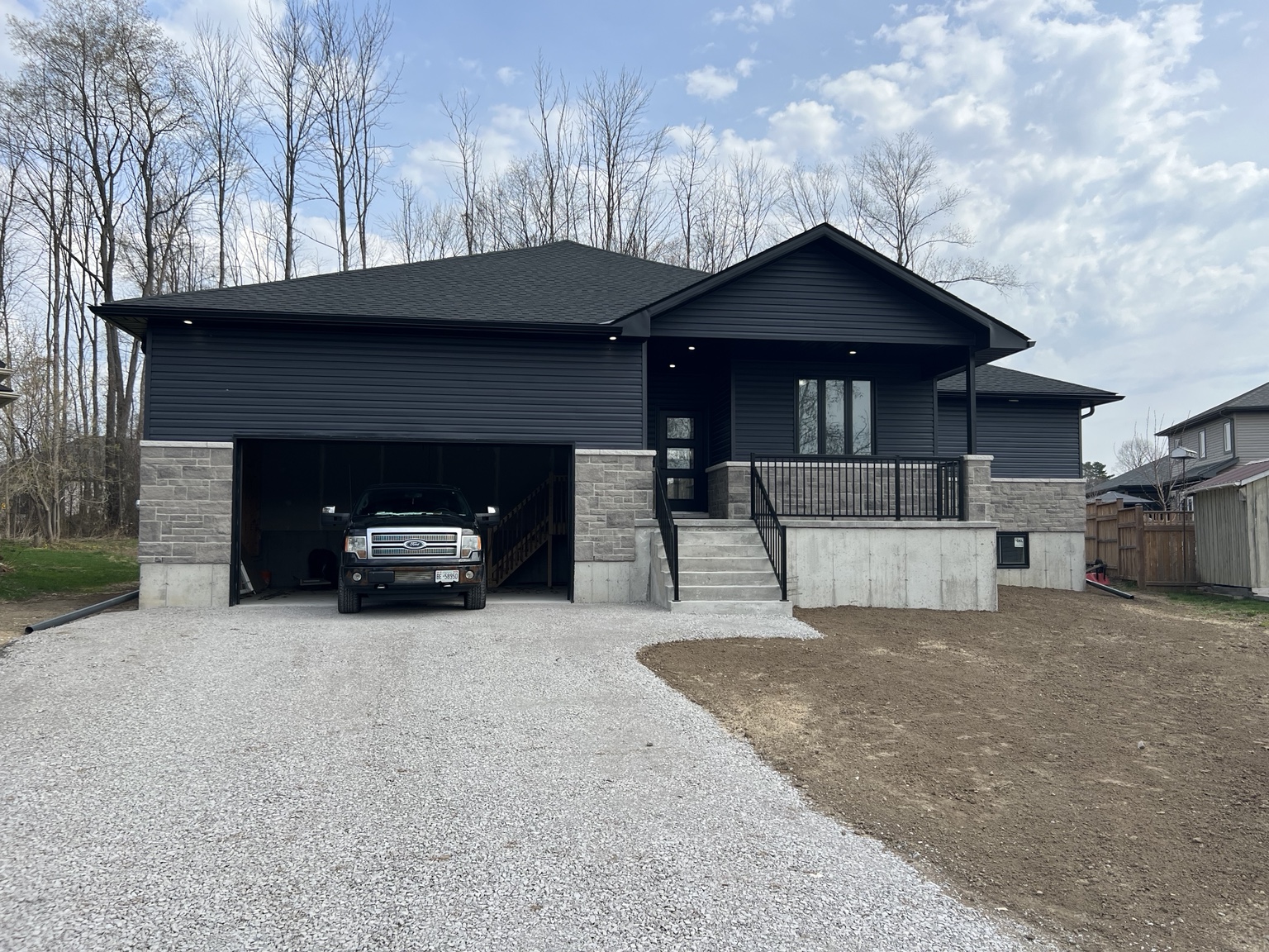 Dark-sided raised bungalow with attached garage and front porch